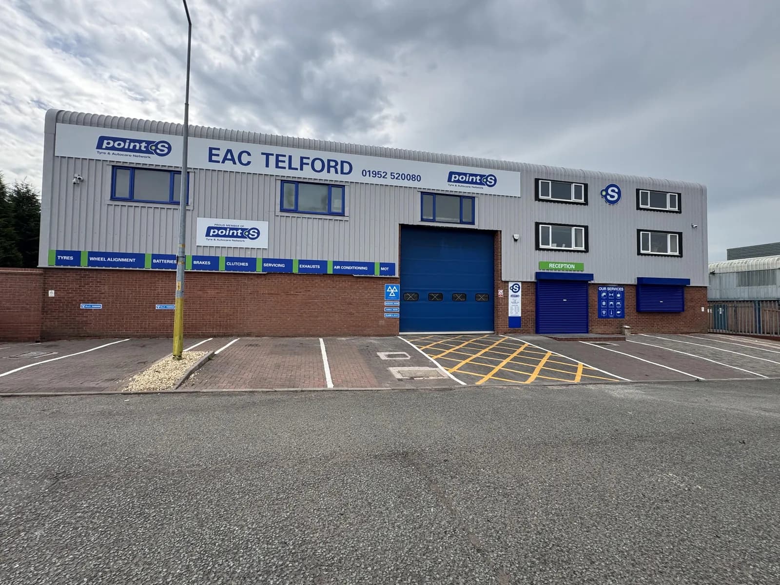 EAC Telford workshop frontage with a blue roller door and marked parking bays